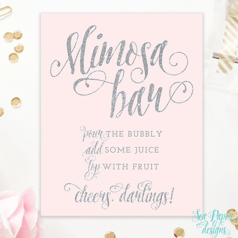 May include: A pink printable sign with silver glitter text that reads "Mimosa Bar" and instructions to "pour the bubbly, add some juice, top with fruit, cheers darlings!"