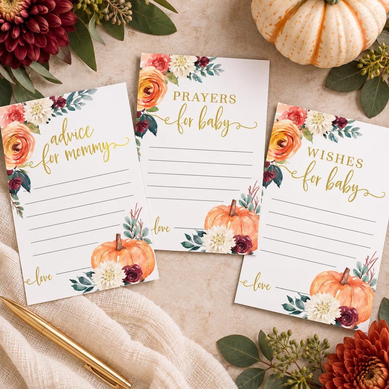 May include: Three rectangular white paper cards featuring watercolor floral arrangements with orange, burgundy, and white flowers, green leaves, and orange pumpkins. The cards have gold text reading Advice for mommy, Prayers for baby, and Wishes for baby.