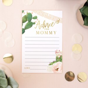 K&ouml;nnte beinhalten: Eine wei&szlig;e Karte mit goldener Aufschrift "Rat f&uuml;r Mama". Die Karte ist mit einem Kaktus und einem Blumendesign verziert.