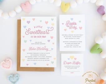 May include: A baby shower invitation set featuring a main card, a books for baby card, and a diaper raffle card. The white cards are decorated with small pastel hearts in pink, blue, yellow, and green, with pink and dark text throughout.