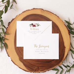 May include: Two white envelopes with gold calligraphy and floral designs. The top envelope has the text "The Refusjons" and the address "9301 109 Avenue North, Grant, Wisconsin 55082". The bottom envelope has the text "The Lorenzinis" and the address "510 Luci Drive, Grant, Wisconsin 55082".