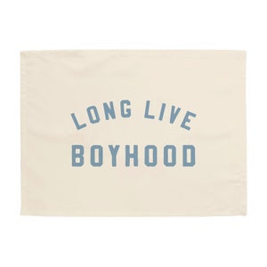 May include: A cream-colored tea towel with the text "LONG LIVE BOYHOOD" printed in blue.