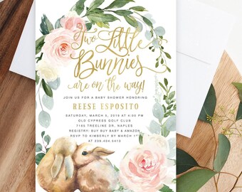 May include: A rectangular baby shower invitation card featuring a watercolor floral wreath with pink roses and green eucalyptus leaves. The text reads Two Little Bunnies are on the way! in gold script, with details for Reese Esposito.