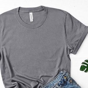 May include: A plain gray t-shirt with rolled up sleeves. The t-shirt is made of a soft, comfortable fabric and has a relaxed fit.