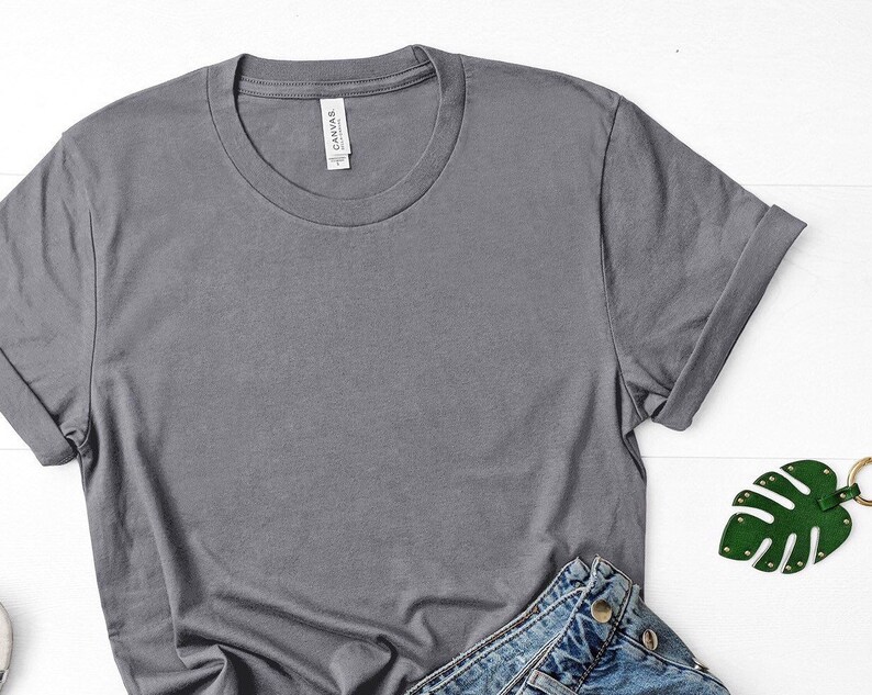 May include: A plain gray t-shirt with rolled up sleeves. The t-shirt is made of a soft, comfortable fabric and has a relaxed fit.