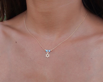 May include: A gold chain necklace with a small gold Star of David pendant and three light blue beads.