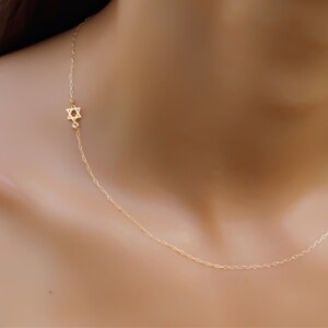 May include: A delicate gold chain necklace with a small Star of David pendant.