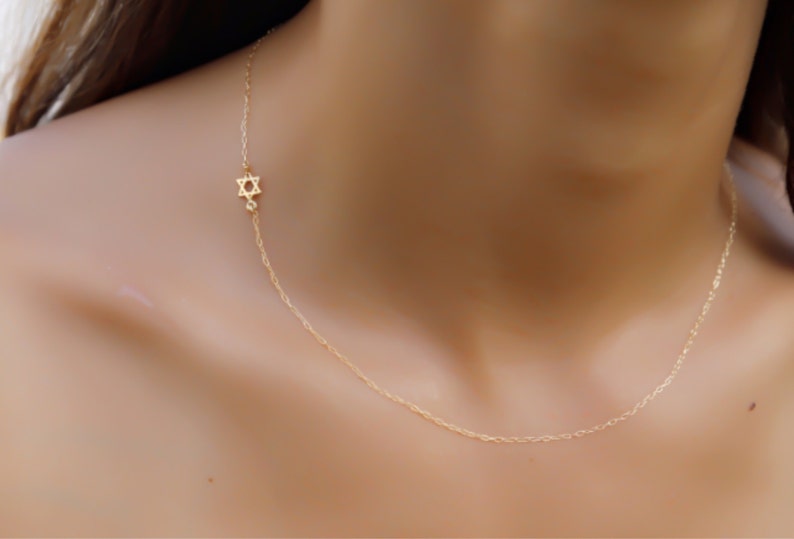 May include: A delicate gold chain necklace with a small Star of David pendant.