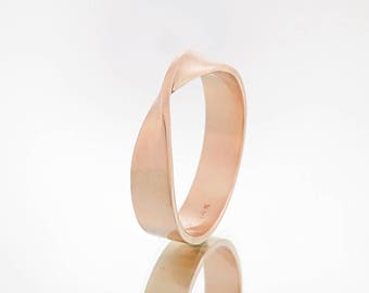 May include: A rose gold band ring with a twisted design. The ring is smooth and polished.
