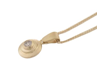 Puede incluir: Un collar de cadena de oro con un colgante que presenta una piedra preciosa redonda facetada engastada en un diseño circular en capas.