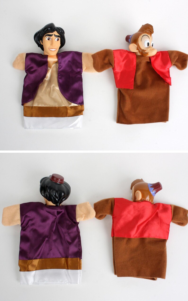 Puede incluir: Dos marionetas de mano con personajes de una popular pel&iacute;cula de animaci&oacute;n. Una marioneta es un personaje con cabello negro, que lleva un chaleco morado y una camisa beige. La otra es un mono marr&oacute;n con un chaleco rojo.