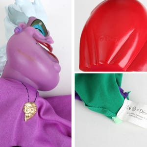 Puede incluir: Mu&ntilde;eca de &Uacute;rsula morada con una diadema blanca y azul, un colgante de concha dorada y una concha roja. La mu&ntilde;eca tiene un vestido morado y mangas verdes y moradas. El logotipo de Disney es visible.