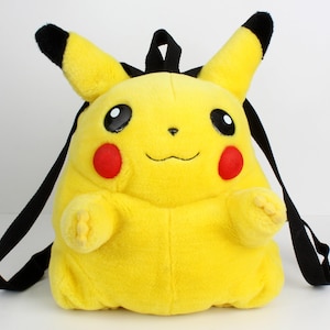 Può includere: Uno zaino di peluche di Pikachu giallo con spalline e orecchie nere. Lo zaino presenta cerchi rossi sulle guance, occhi neri e una bocca sorridente. Lo zaino di peluche è progettato per assomigliare al popolare personaggio dei Pokémon.