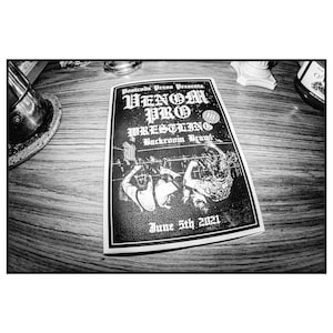 May include: Black and white flyer for a wrestling event called "Venom Pro Wrestling: Backroom Brawl" on June 5th, 2021. The flyer features a photo of two wrestlers in the ring.