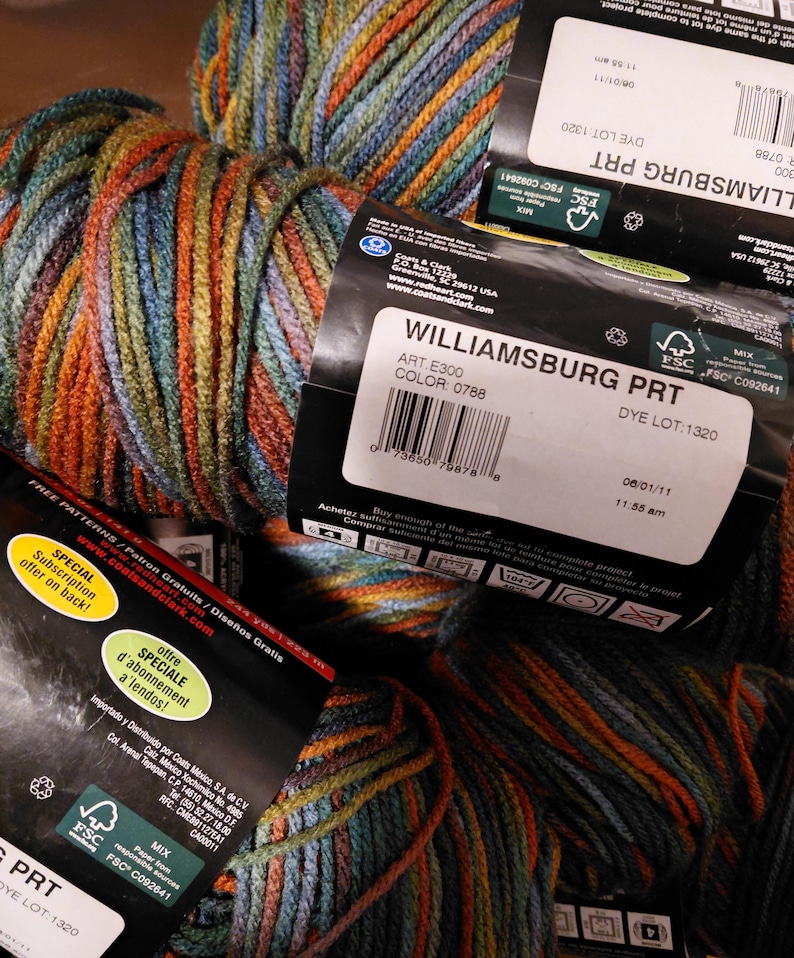 May include: Close-up of several skeins of Williamsburg PRT yarn. The yarn is a mix of colors including orange, blue, green, and brown. The labels show the color code 0788 and the dye lot 1320. The yarn is suitable for knitting and crochet projects.