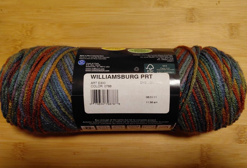 May include: A skein of Williamsburg PRT yarn in color 0788. The yarn is a mix of blue, green, orange, and yellow. The label includes the text "WILLIAMSBURG PRT", "ART E300", and a barcode.