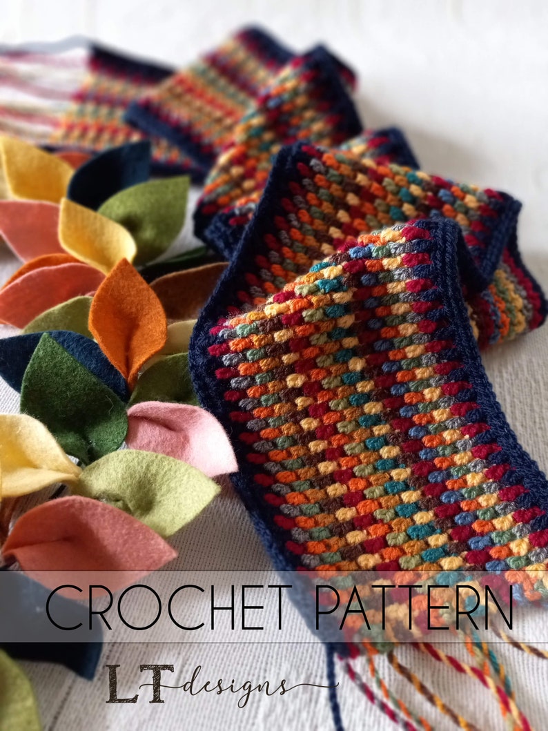 May include: A crochet pattern for a colorful scarf with a navy blue border. The pattern is called "LT designs".