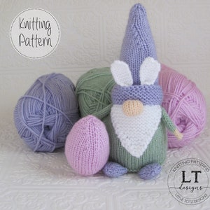 Może przedstawiać: Wzór na szydełku na wielkanocnego gnoma z uszami królika. Gnom nosi fioletowy kapelusz, białą brodę i zielony sweter. Wzór zawiera kłębki wełny w kolorze fioletowym, zielonym i różowym.