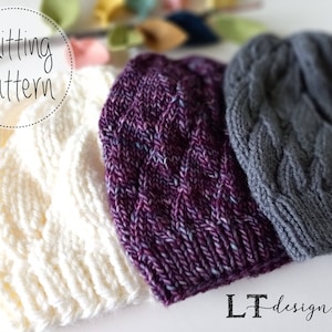 Puede incluir: Tres gorros tejidos de diferentes colores: blanco, morado y gris. Los gorros están apilados uno encima del otro. El texto "Knitting Pattern" está escrito en un círculo sobre los gorros. El texto "LT Designs" está escrito debajo de los gorros.