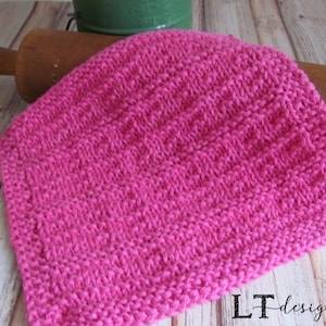 May include: A pink knitted dishcloth with a textured pattern. The dishcloth is made with a soft yarn and is perfect for cleaning dishes or drying hands.