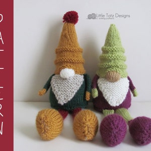 Pode incluir: Dois gnomos de malha, um com um chapéu verde e calças roxas, o outro com um chapéu amarelo e calças verdes. Ambos os gnomos têm barbas brancas e estão sentados numa superfície branca. "Little Totz Designs" está escrito no canto superior direito da imagem.