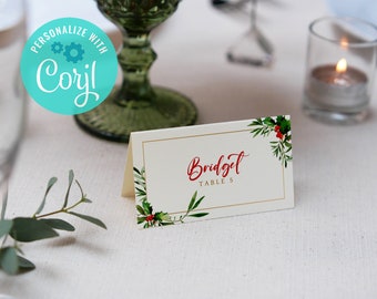 Puede incluir: Una tarjeta de lugar blanca con un borde dorado y un diseño de acebo verde y rojo. La tarjeta dice "Bridgit Table 5".