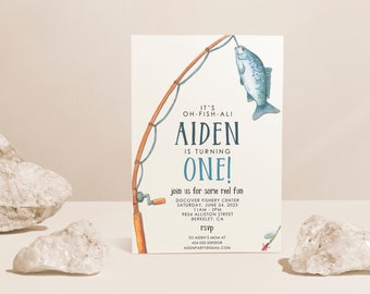 May include: A blue and white illustrated invitation for a first birthday party with a fishing rod and fish. The text reads "It's Oh-Fish-Ali Aiden is turning One! Join us for some reel fun. Discover Fishery Center Saturday, June 24, 2023 11AM-2PM 9854 Alliston Street Berkeley, CA RSVP To Aiden's Mom at 454-555-5585POR AidenPartyBmail.com"