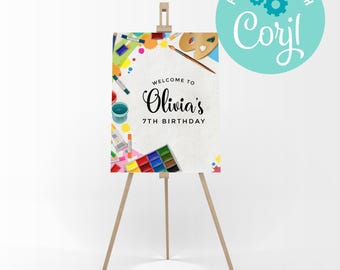 Può includere: Un cavalletto di legno espone un cartello di compleanno con la scritta "Welcome to Olivia's 7th Birthday". Il cartello è decorato con materiali artistici colorati, tra cui tubetti di vernice, tavolozze e acquerelli. Un cerchio turchese con la scritta "Personalize with Corjl" è in alto a destra.