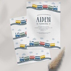May include: A blue train with colorful cars on a white background. The text "JOIN US TO CELEBRATE AIDEN IS TURNING 3!" is at the top of the invitation. The invitation also includes the date, time, and location of the party.