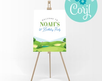 May include: Welcome to Noah's 1st Birthday Party sign with a golf course illustration. The sign is on a wooden easel.