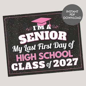 May include: A rectangular sign with a black chalkboard background featuring white and pink text that reads I'M A SENIOR My Last First Day of HIGH SCHOOL CLASS of 2027. A pink graduation cap icon is centered at the top with white speckles throughout.