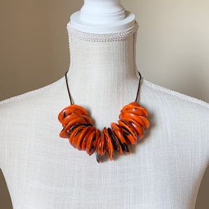 Naszyjnik Aros| Pomarańczowy naszyjnik Tagua| Naszyjnik Tagua Statement| Biżuteria Boho| Biżuteria Tagua| Naszyjnik Tagua i Bombona Seed