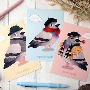 A set of three A6 size postcards all with illustrated pigeons, one wearing a bowler hat and waistcoat on a yellow background, another wearing a beret and neck scarf on a blue background and the third wearing a matador costume on a pink background