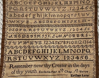 Peut inclure: Un sampler brun avec un fond beige représentant l'alphabet, les chiffres et la citation "Remember now thy Creator in the days of thy youth. Ecclesiastes sath Chap. st Verse. Esther Law".