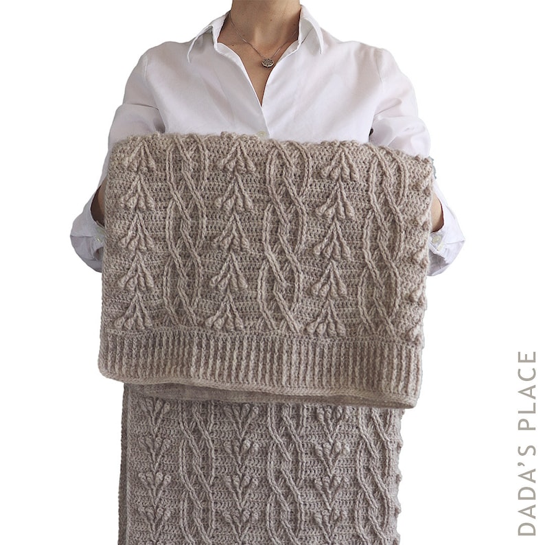 May include: A beige crochet blanket and skirt set with a textured leaf pattern. The blanket is rectangular, and the skirt is a similar design. The set is held up against a white background.
