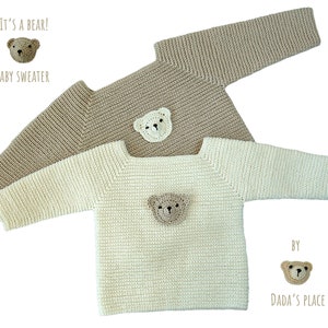May include: Two knitted baby sweaters with bear appliques. The sweater on top is beige and the sweater on the bottom is white. Both sweaters have a bear applique on the front. The text "It's a bear!" and "Baby Sweater" are above the top sweater. The text "By Dada's Place" is below the bottom sweater.