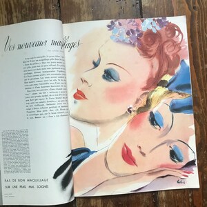 Pu&ograve; includere: Pagina di rivista vintage con un'illustrazione di moda di tre volti di donna. L'opera presenta rossetto rosso, ombretto blu e dettagli floreali. Il testo recita "Vos nouveaux maiflages" e "Pas de bon maquillage sur une peau mal soign&eacute;e."