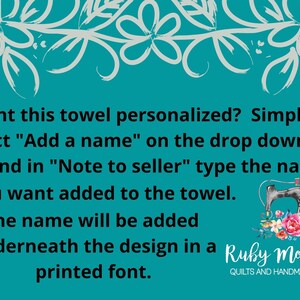 May include: A teal blue background with white floral border and text that reads: Want this towel personalized? Simply select "Add a name" on the drop down box and in "Note to seller" type the name you want added to the towel. The name will be added underneath the design in a printed font.  Ruby Mozelle's Quilts and Handmade Goods.