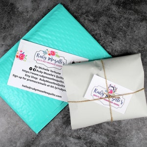 May include: A turquoise bubble mailer with a business card that reads "Ruby Mozelle's Quilts and Handmade Goods" and includes contact information. A second business card with the same text is tied with twine to a white package.