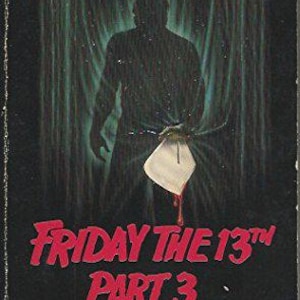 Può includere: Copertina del libro "Venerdì 13 Parte 3". L'immagine presenta una figura oscura su uno sfondo verde, che tiene un oggetto bianco con una macchia rossa. Il titolo è in rosso, con il nome dell'autore e il riferimento al film sottostante.