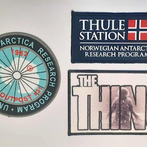 以下が含まれることがあります： 3つの刺繍パッチ。南極大陸の地図の周りに「UNITED STATES ANTARCTICA RESEARCH PROGRAM」と「U.S. OUTPOST #31」と書かれた円形パッチ。 「THULE STATION」とノルウェーの国旗が描かれた長方形パッチ。 「THE THING」と書かれた長方形パッチ。