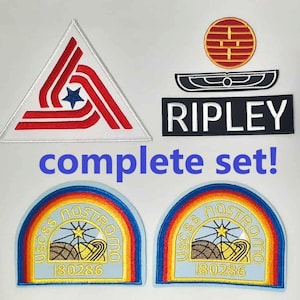 Op de afbeelding: Een complete set geborduurde patches. Bevat een driehoekige patch met rode en witte strepen, een zwart-witte naam patch "RIPLEY" en twee patches met een regenboogboogontwerp en de tekst "USCSS NOSTROMO".