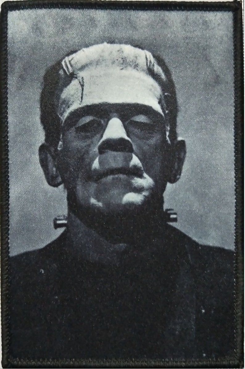 Pu&ograve; includere: Immagine in bianco e nero del mostro di Frankenstein, un personaggio classico dell'orrore. L'immagine &egrave; stampata su una toppa di tessuto nero.