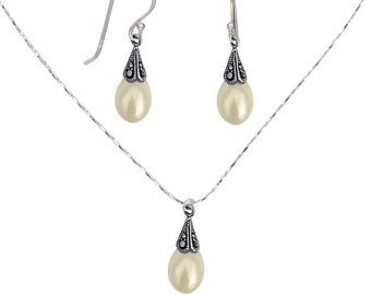 Peut inclure: Un collier et des boucles d'oreilles en argent avec un pendentif en forme de larme de perle et des boucles d'oreilles assorties. Le pendentif et les boucles d'oreilles sont ornés de pierres de marcassite noires.