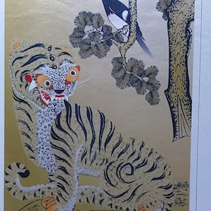 May include: A white tiger with black stripes sits on a gold background. The tiger has a fierce expression with large, round eyes and sharp teeth. A black and white bird sits on a branch of a pine tree in the top right corner of the image.