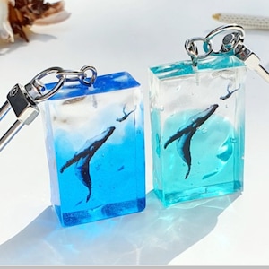 海でクジラとダイバーの出会いを描いたデザインのキーホルダー2個