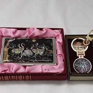 Estuche para tarjetas de visita de nácar con diseño de grúa y llavero con diseño de bambú
