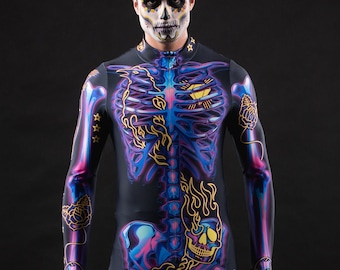 May include: A person wearing a black and purple skeleton costume with gold accents. The costume features a skull design on the chest and legs. The person is wearing black boots.