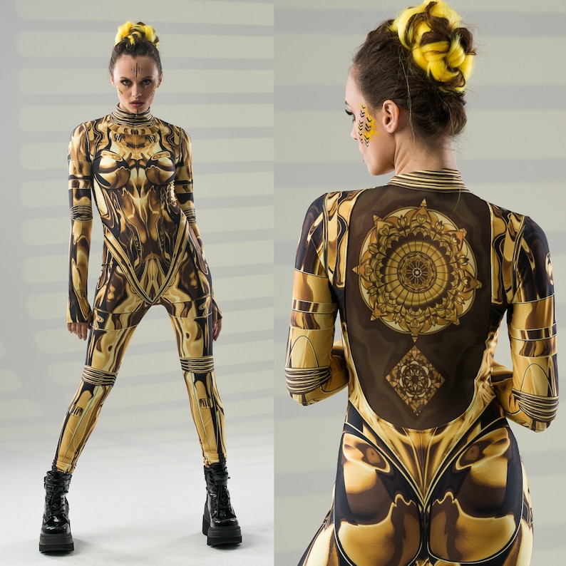 Pu&ograve; includere: Due donne indossano tute a stampa oro e nero. Le tute hanno un design geometrico con un motivo a mandala sul retro. Le donne hanno i capelli raccolti e hanno il trucco sul viso.