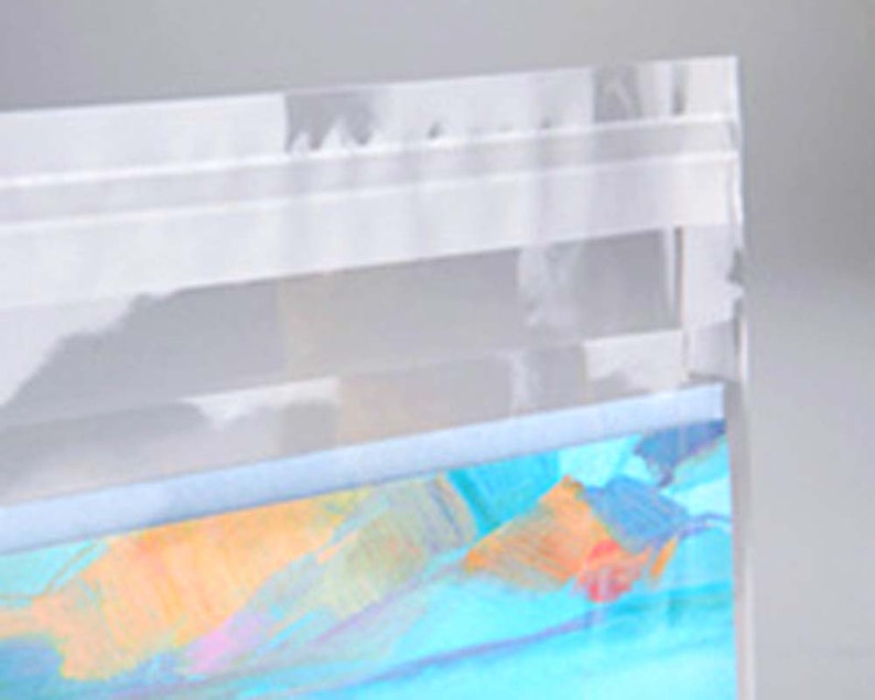 May include: A clear plastic bag with a blue and orange iridescent pattern on the bottom. The bag has a white zipper closure.